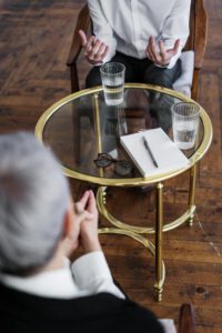 zwei Menschen an einem kleinen runden Tisch im Gespräch